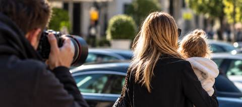 Paparazzo fotografiert eine Mutter mit ihrem Kind in einer privaten Alltagssituation.