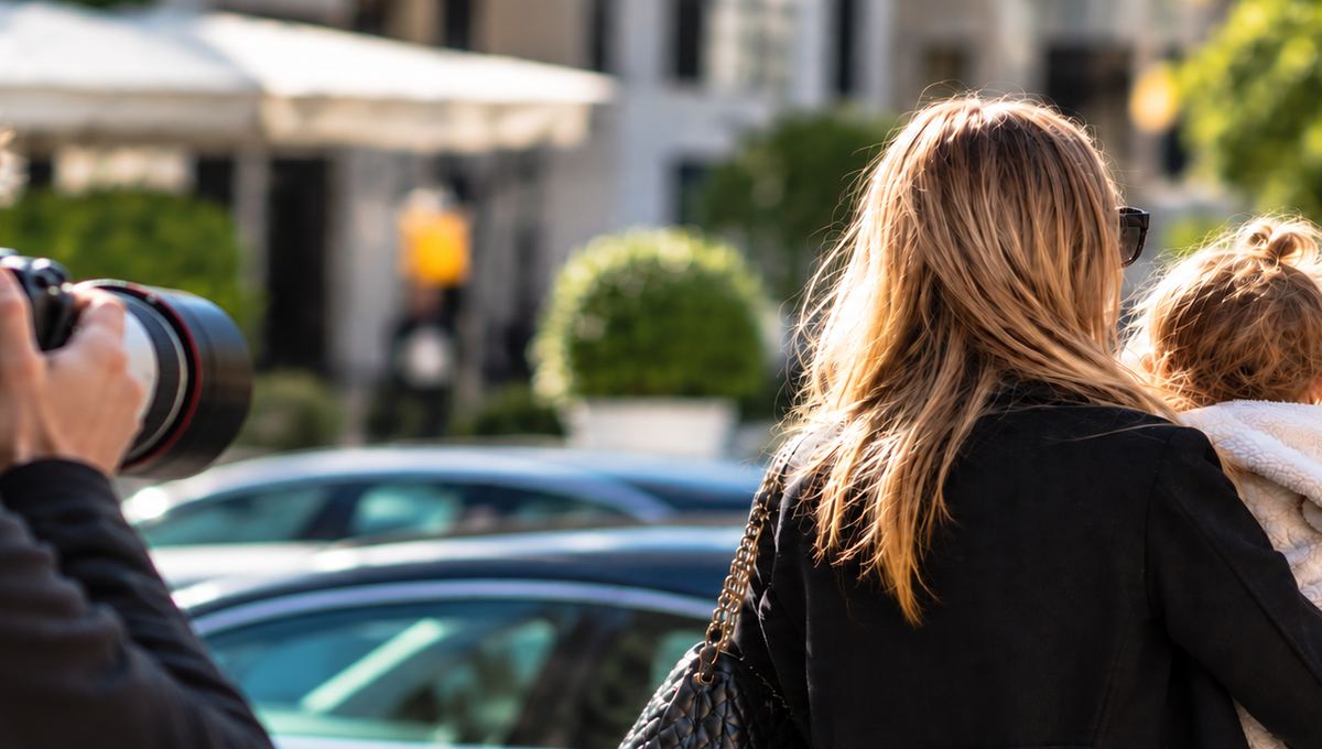 Paparazzo fotografiert eine Mutter mit ihrem Kind in einer privaten Alltagssituation.
