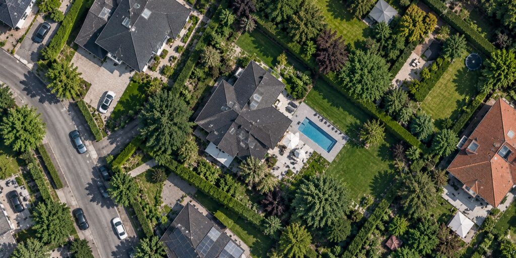 Satellitenansicht einer Wohngegend mit Häusern, Gärten und privaten Grundstücken aus der Vogelperspektive.